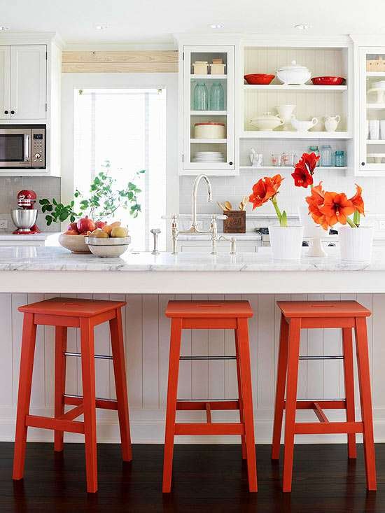 adding brightly colored stools brightens up a white kitchen with a budget friendly pop of color