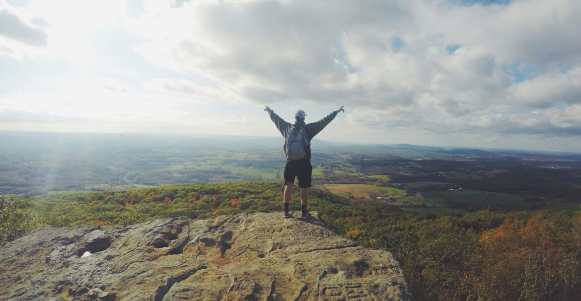 man standing on top of the mountain